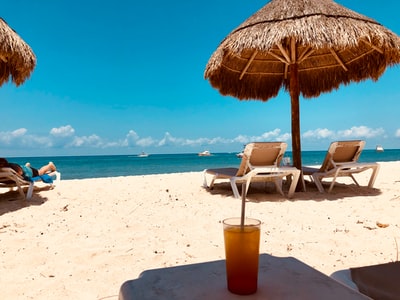 棕色阳伞和沙滩上的两把沙滩椅